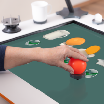 Adult hand is using a ball object to train with Myro