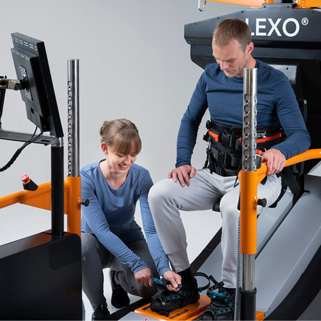 Therapist closes foot attachement of patient on Lexo robotic gait trainer
