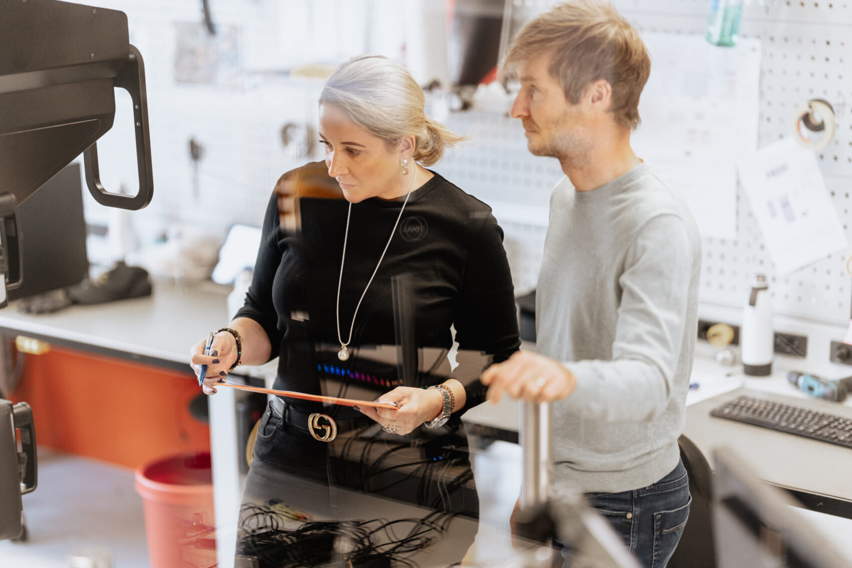 A man and a woman reviewing a Tyromotion therapy device on the production floor.