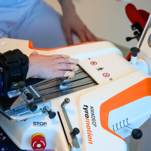 Patients hand on finger rehabilitation equipment Amadeo