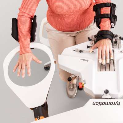 Amadeo with RMT module. A woman is sitting at Amadeo doing bilateral therapy.