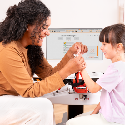 Therapist putting on Amadeo Fingertips on young girl smiling
