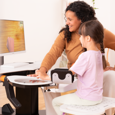 Therapist trains with girl on Amadeo with robotic mirror therapy tool