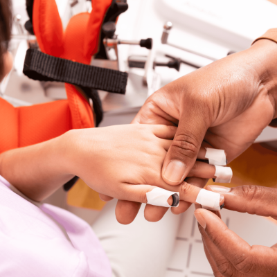 Therapist puts Amadeo Fingertips on young patient