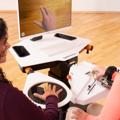 Patient trains on amadeo rmt with the support of a therapist