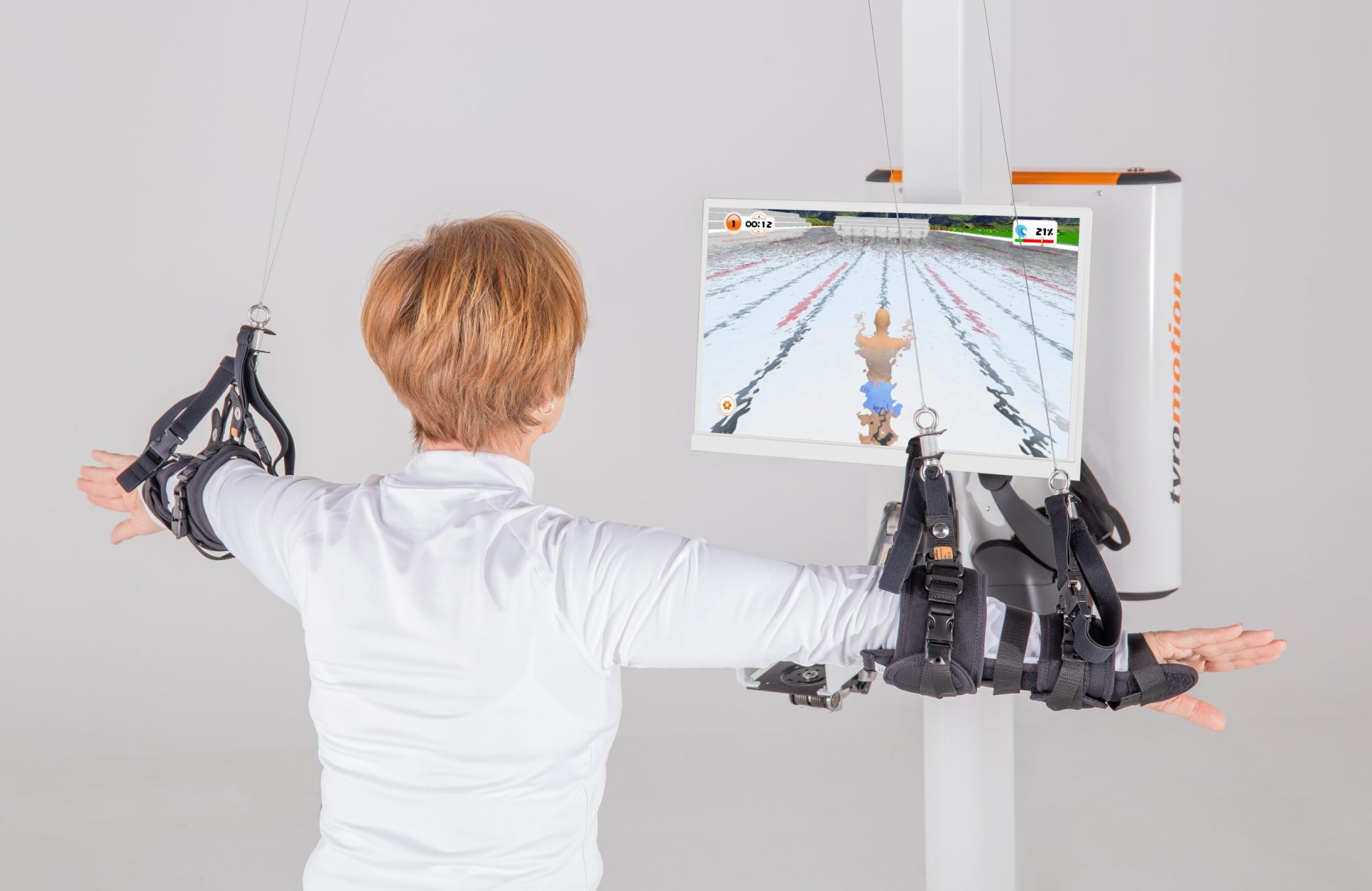 Woman is training with robotic arm rehabilitation