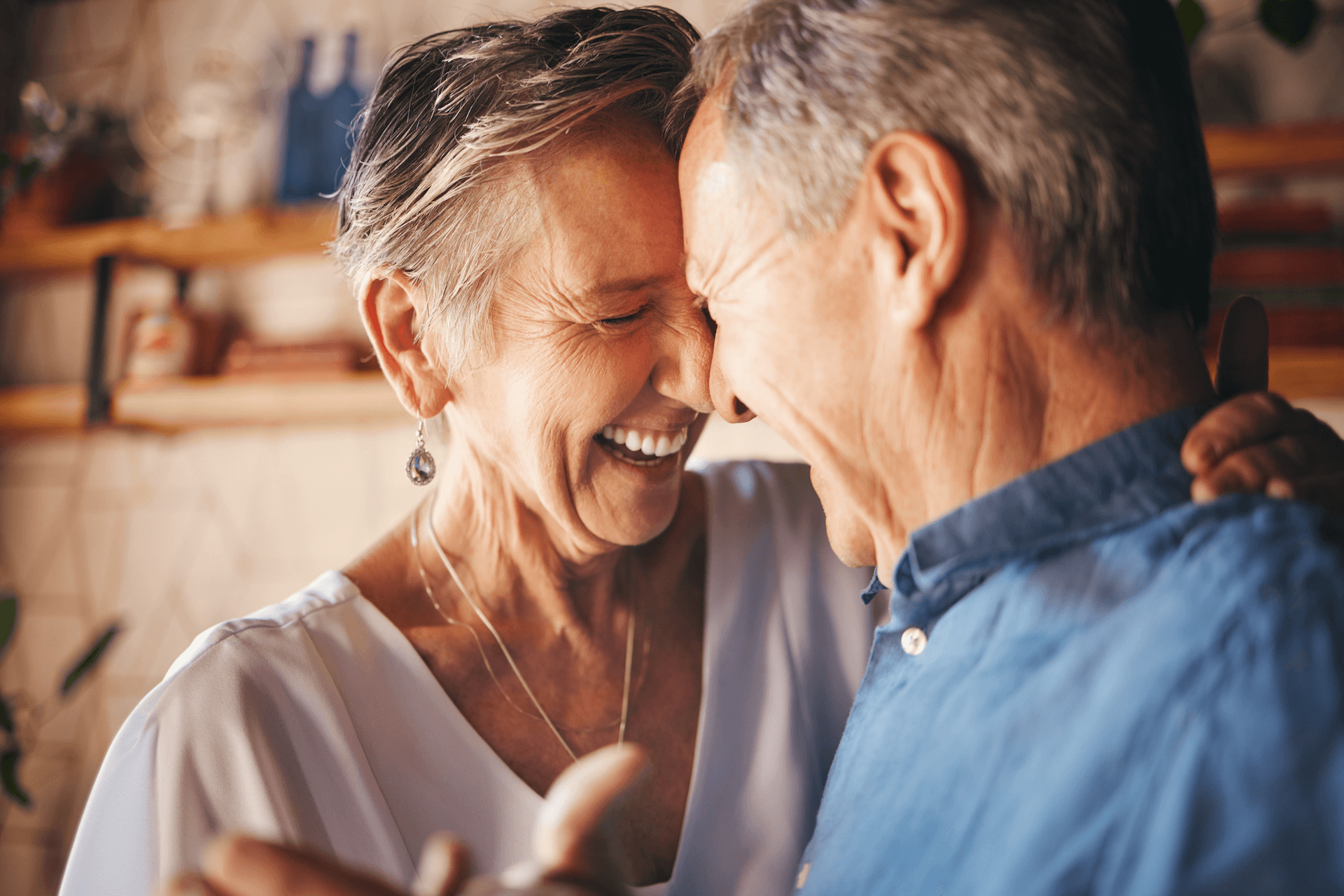 An older woman and an older man laughing together.
