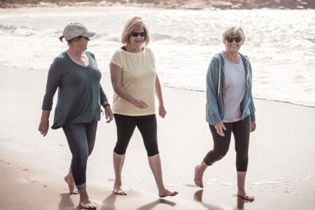 Group of three senior woman walking at the beach
