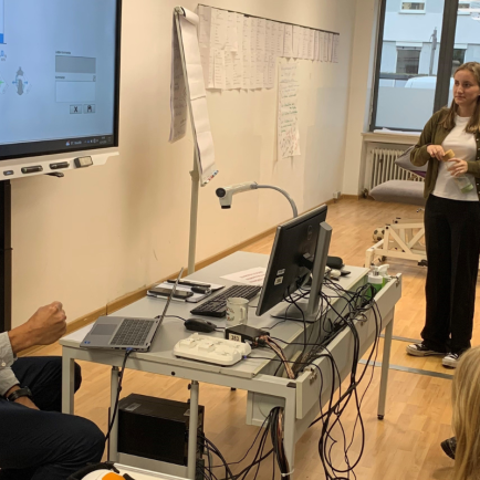 A therapist presenting in front of a group of people in a therapy room