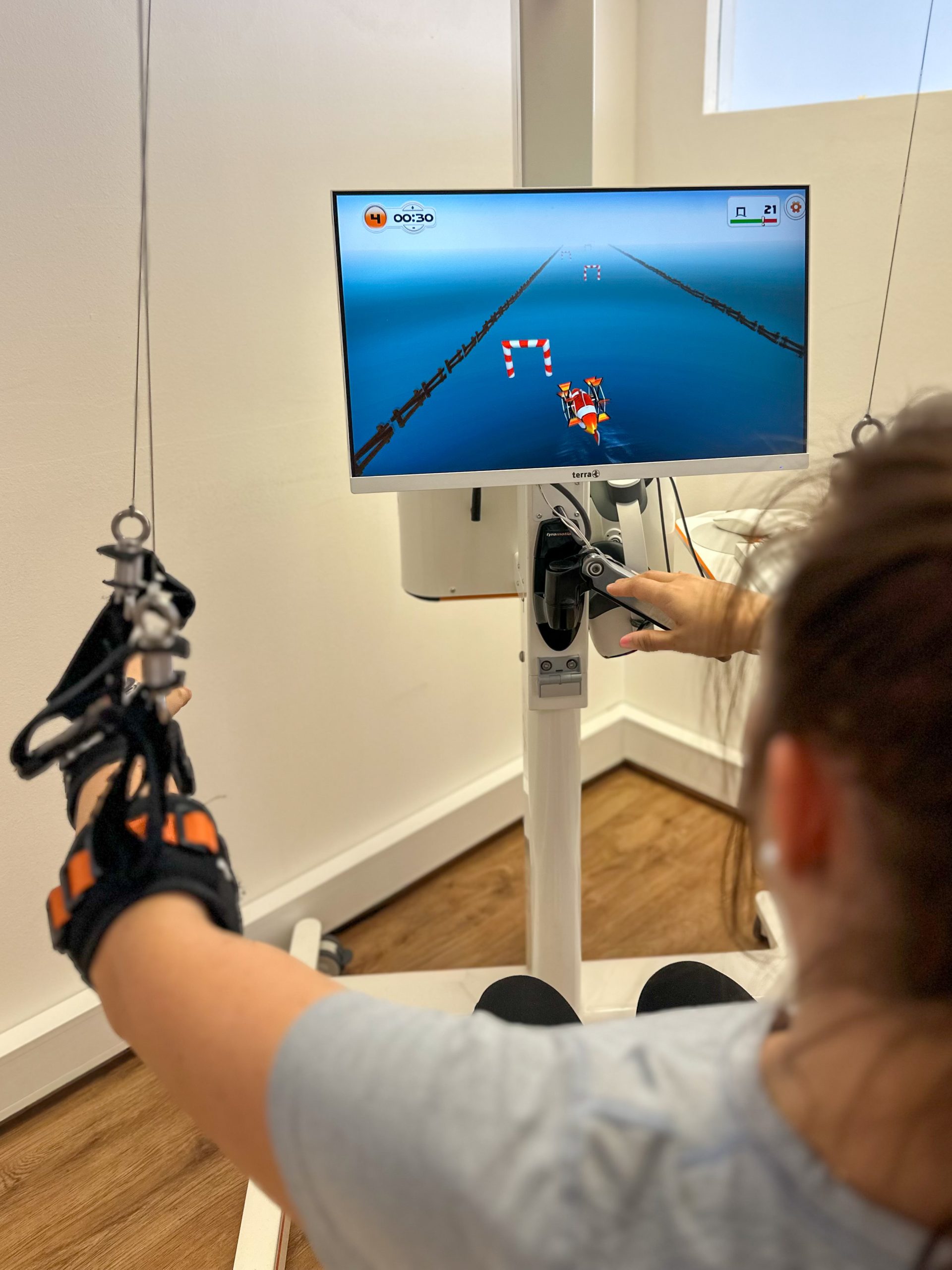 A patient sitting at Myro and playing the new tyroS 6.8 game Paddle Boat