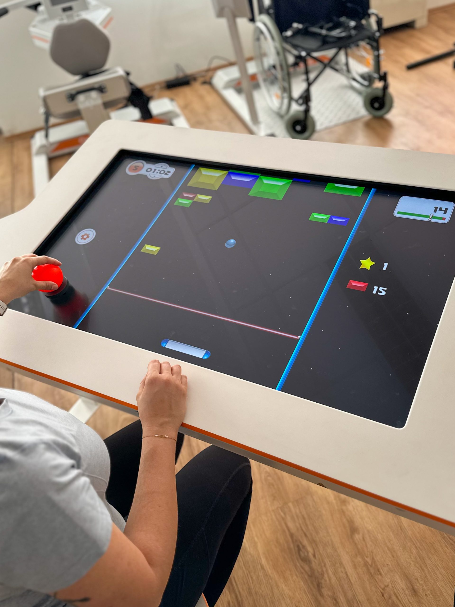 A patient sitting at Myro and playing the new tyroS 6.8 game Bricks Breaker