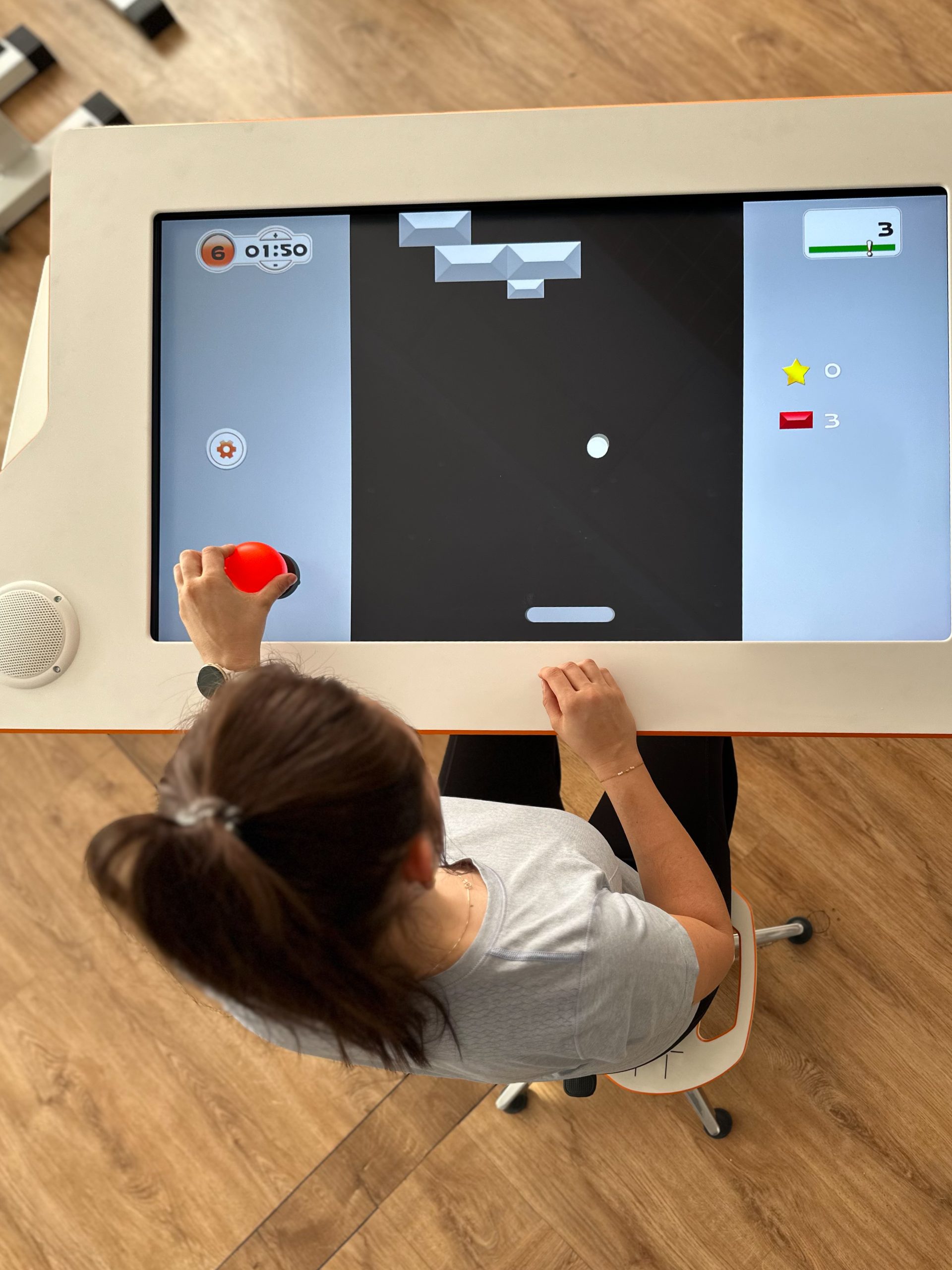 A patient sitting at Myro and playing the new tyroS 6.8 game Bricks Breaker
