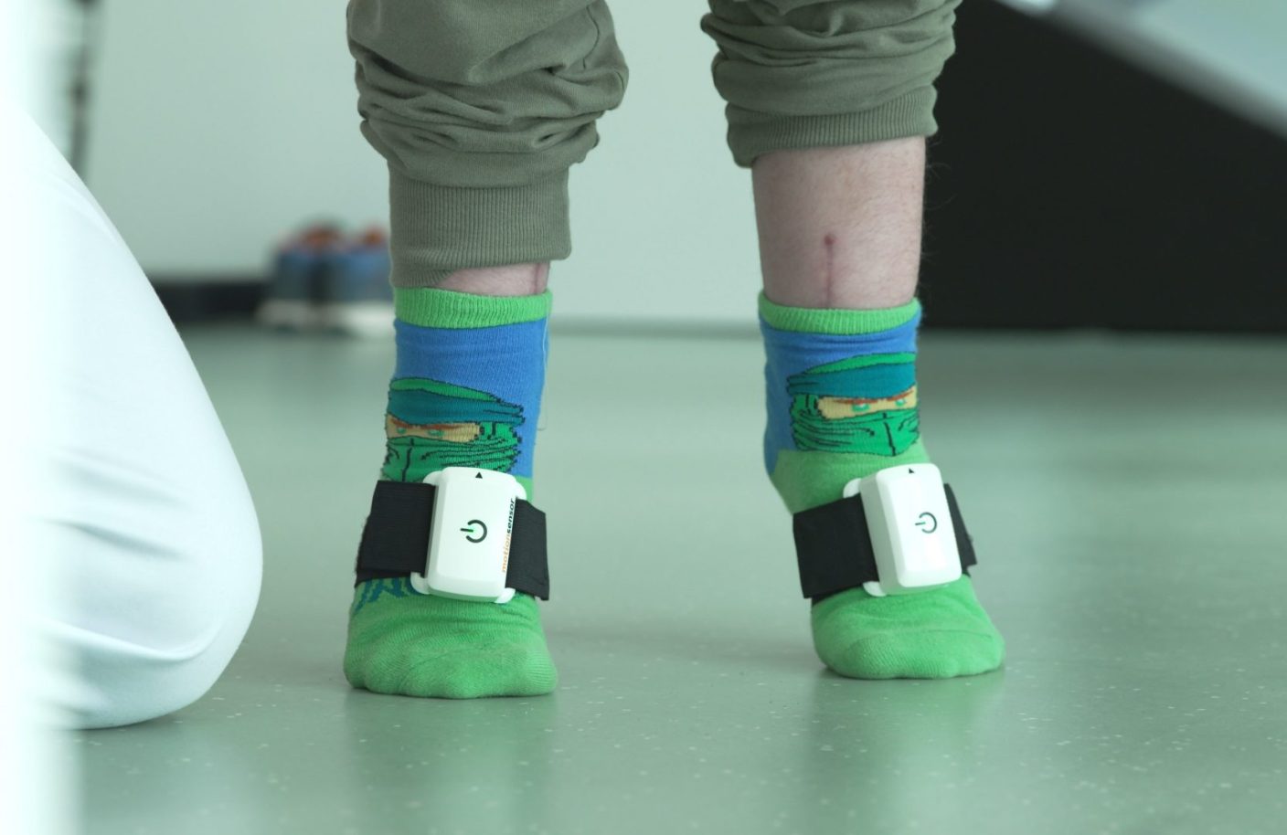 Child with Ninja socks in physiotherapy with Pablo motion sensors on the feet