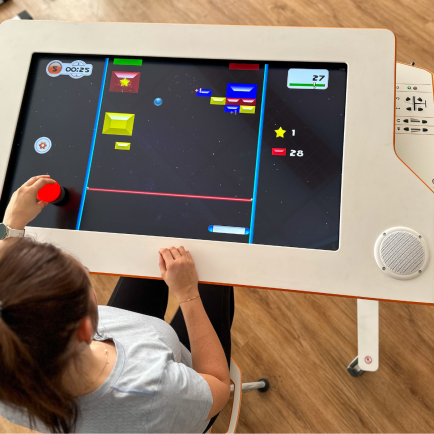 A patient sitting at Myro and playing the new tyroS 6.8 game Bricks Breaker