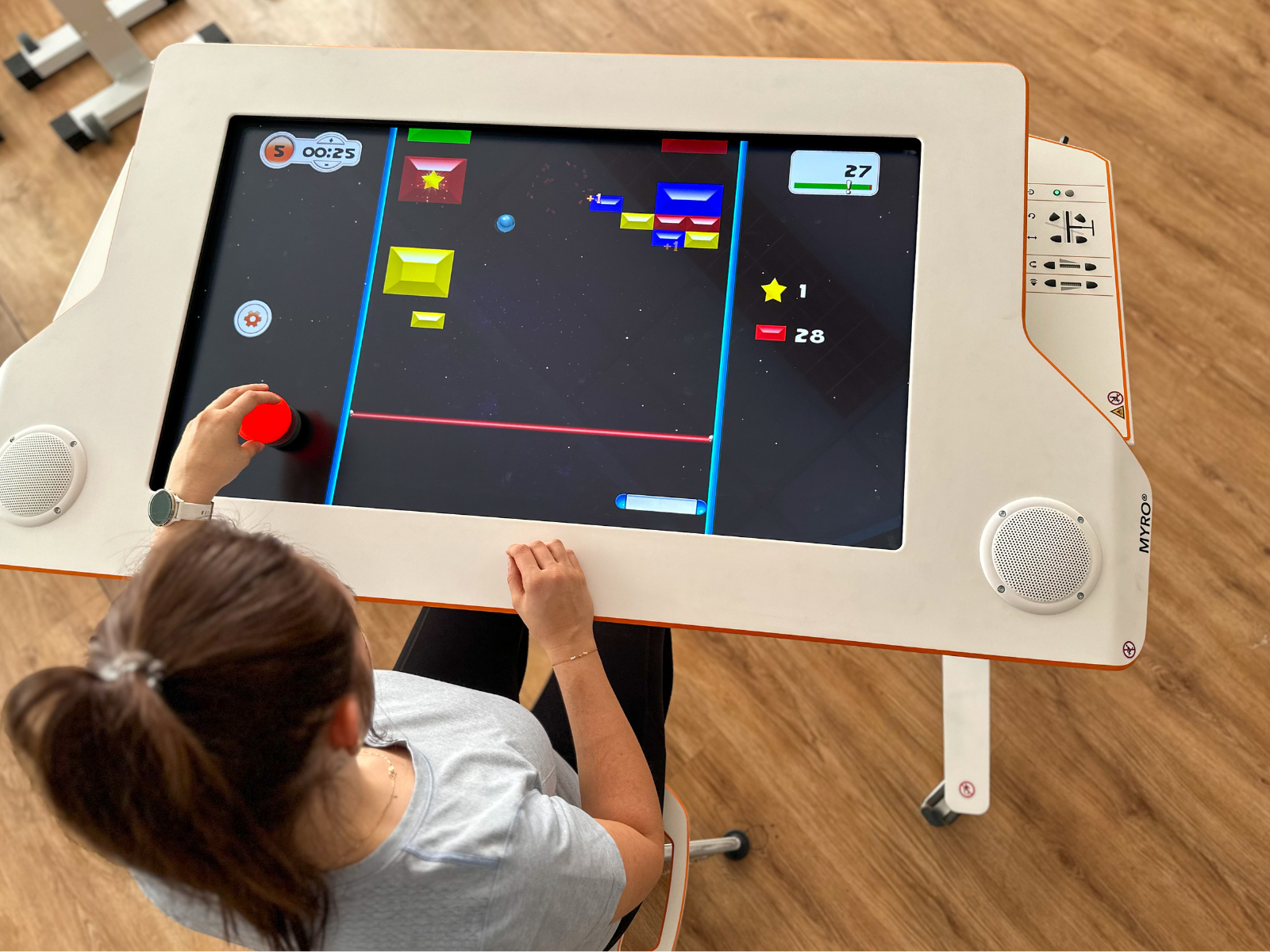 A patient sitting at Myro and playing the new tyroS 6.8 game Bricks Breaker