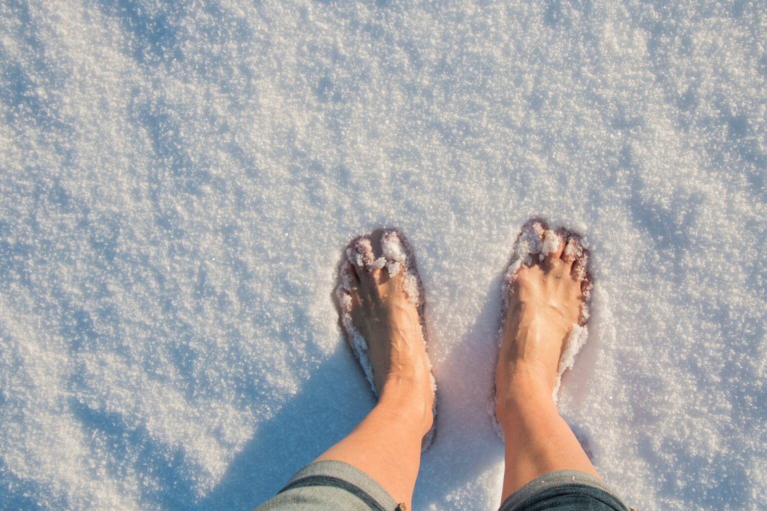 Stock Picture: Feet from a woman without shoes in snow