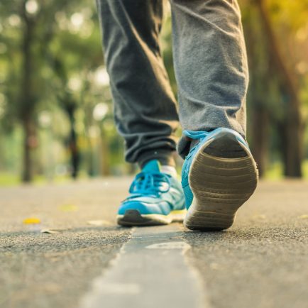 Feet with sport shoes from a woman walking in the park