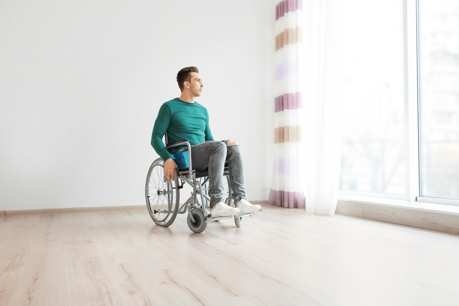 Young men in a wheelchair in a empty room