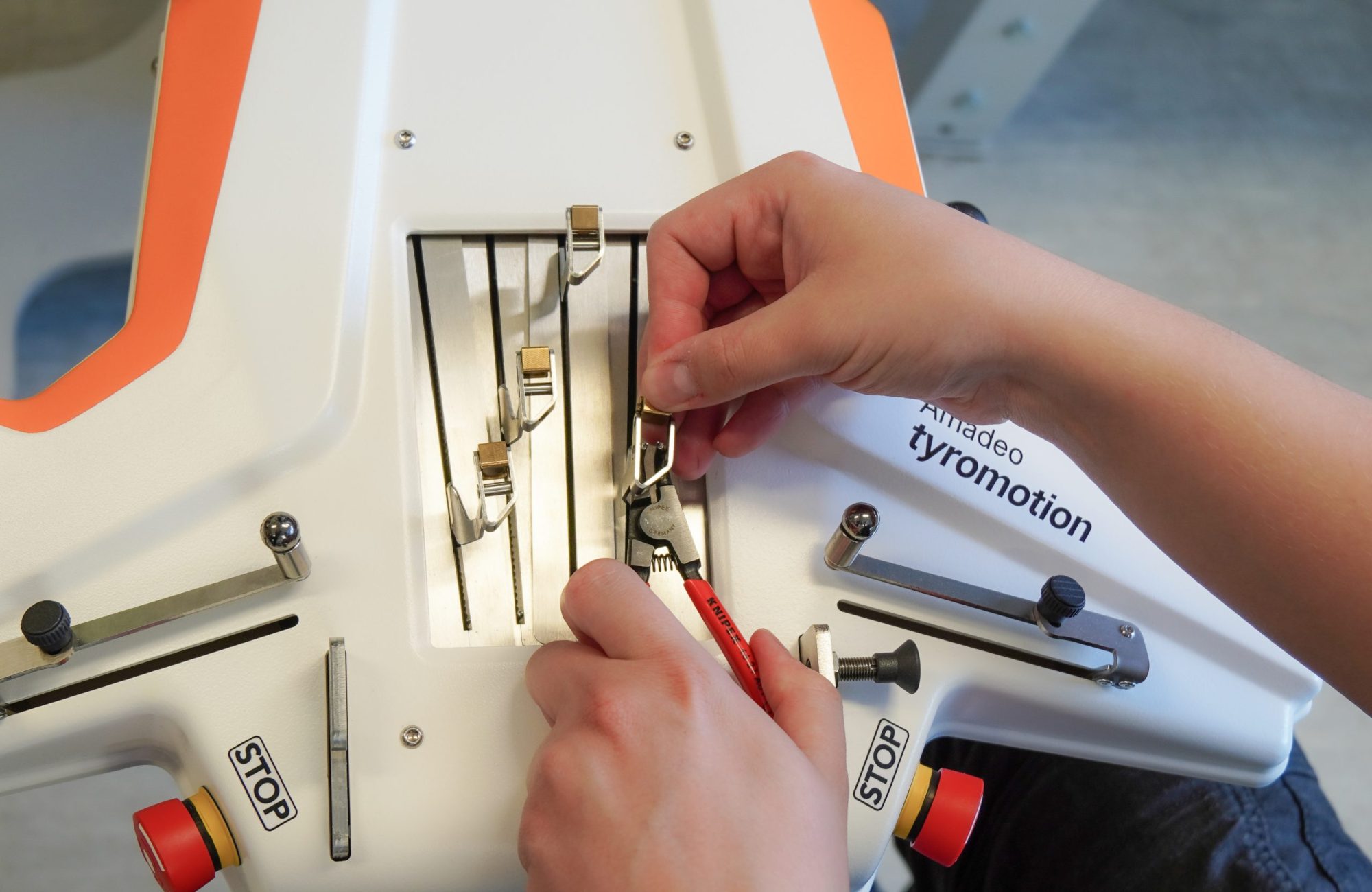 Hands from an service employee working on finger hand rehabilitation device Amadeo