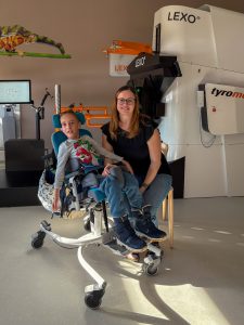 Patient Elias Haitzinger and his mother Melanie sitting in a interview situation in front of gait trainer Lexo