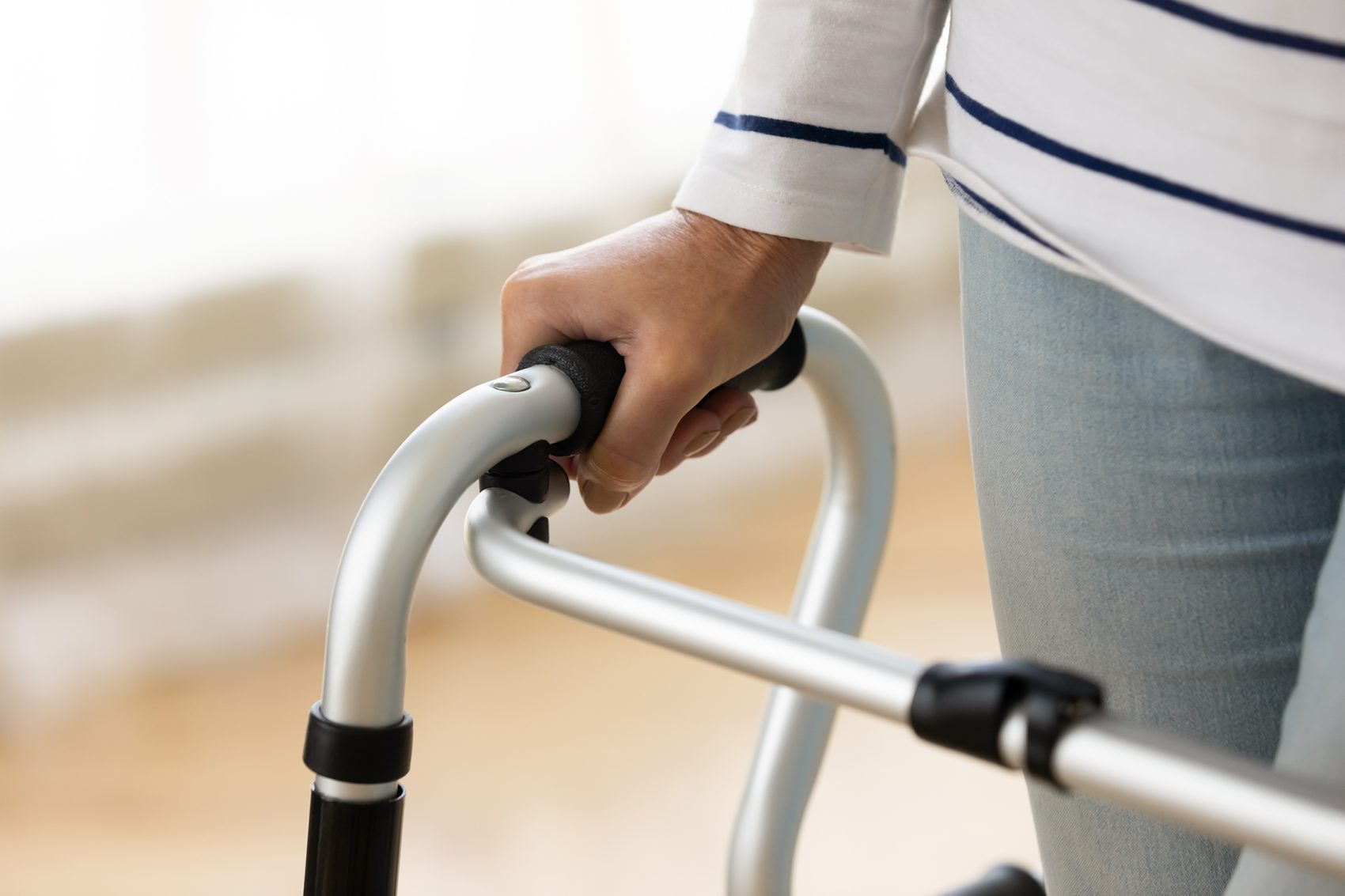 A hand of a woman holding on a walker