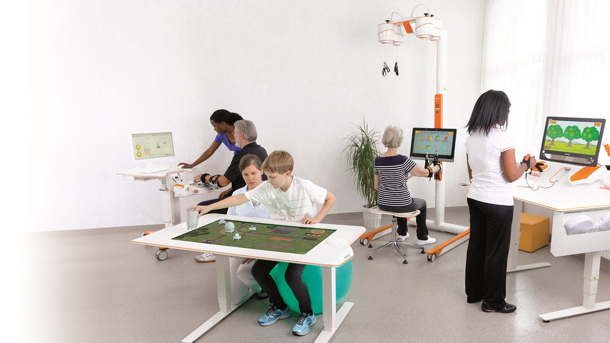 Tyromotion devices in one room with patient and therapists. Patients using the devices Diego, Myro, Amadeo and Pablo.