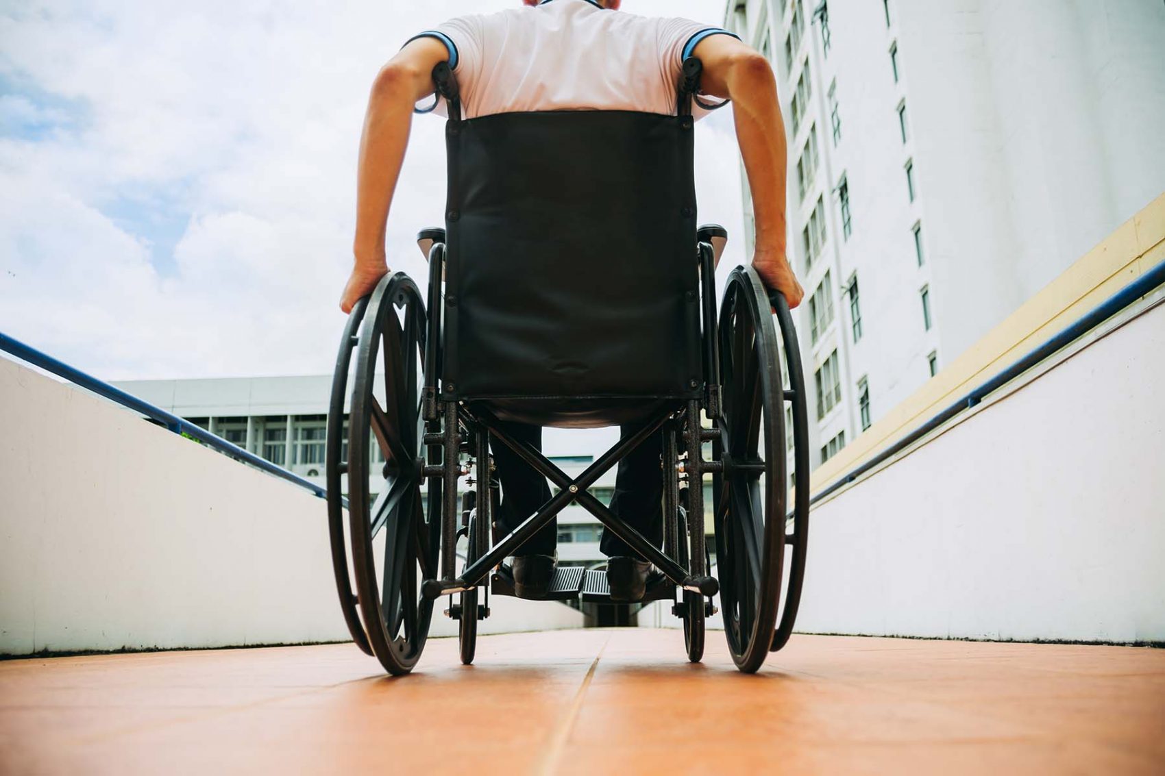 Picture of a person sitting in a wheelchair, perspective from the back