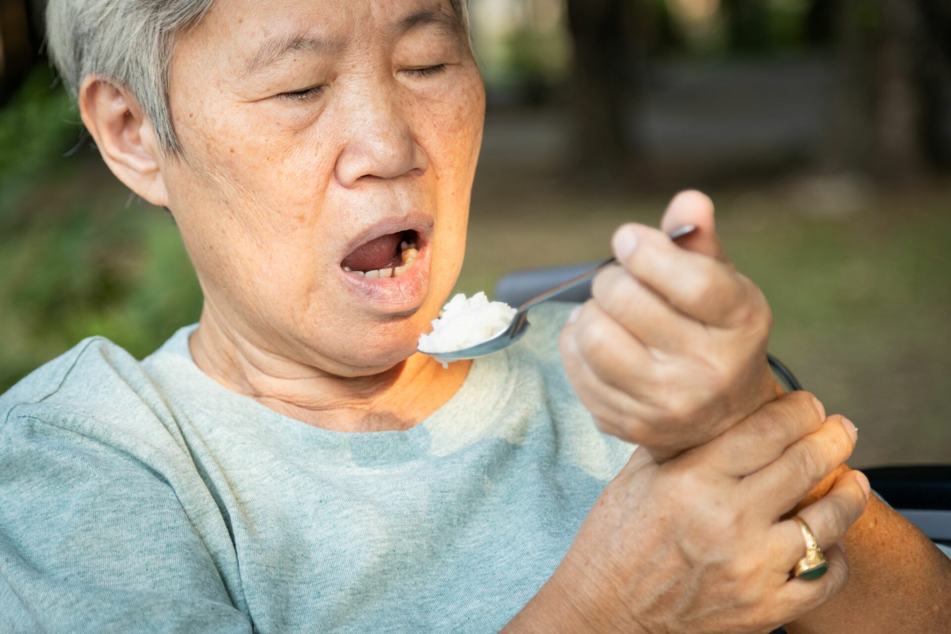 older woman holding spoon with both hands
